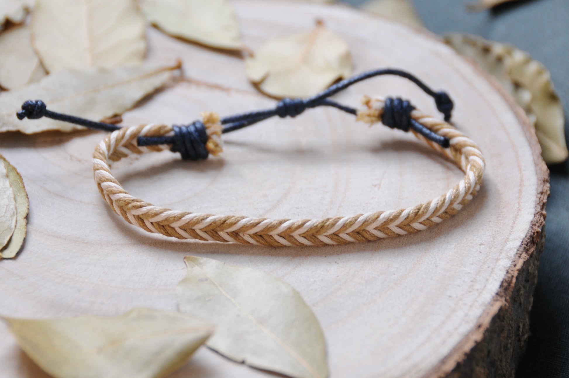 Bracelet pour homme Acacia : cordes tressées beige et blanc, finitions bleu marine. Bracelet ajustable grâce à sa fermeture coulissante. Bracelet tendance et à prix abordable. Idée cadeau homme idéale. Sauvage Bracelets